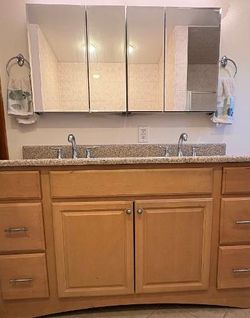 Oak finish vanity, fully assembled with double sink, pebbled counter, and backsplash