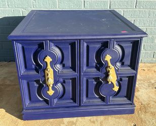 Wooden nightstand with gold handles in good condition.