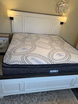 Kind Size Bed with mattress and lamps.