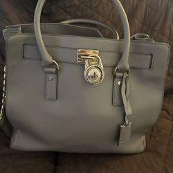 Authentic Michael Kors Satchel In Excellent Condition. It Is Gray And Has God Accents. No Stains,rips Or Scratches. Inside Is In The Same Condition. 