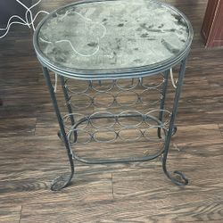 Black Metal And Glass Table Holds Wine Bottles. 