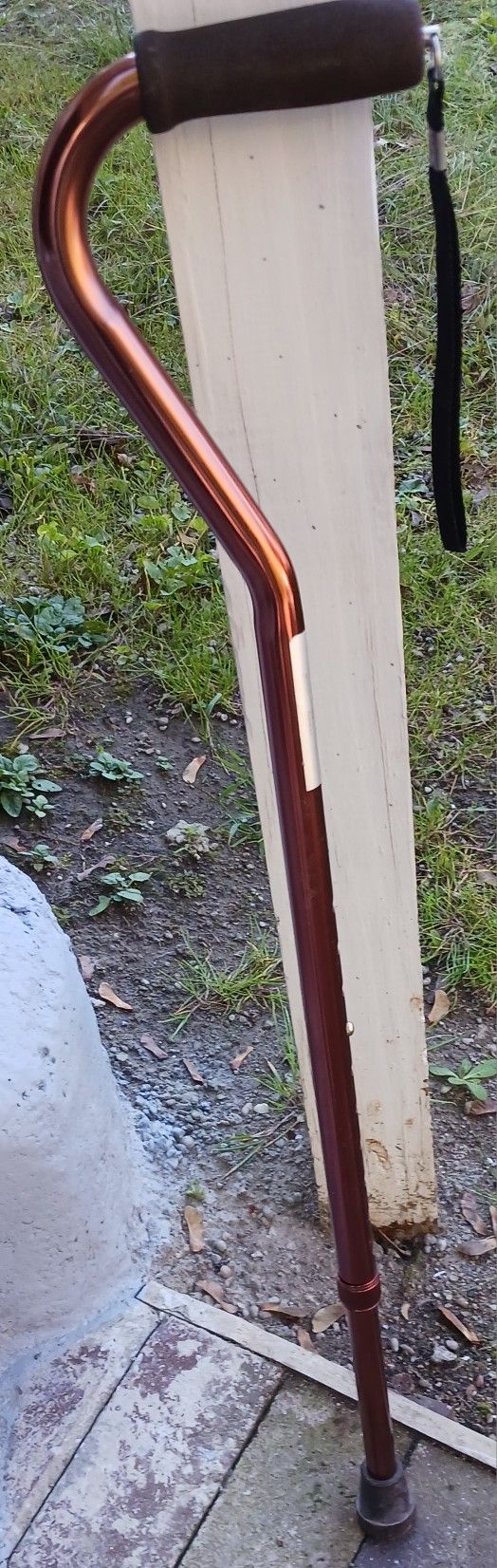 LIKE NEW COPPER COLOR CANE WITH BLACK HANDLE AND WRIST BAND