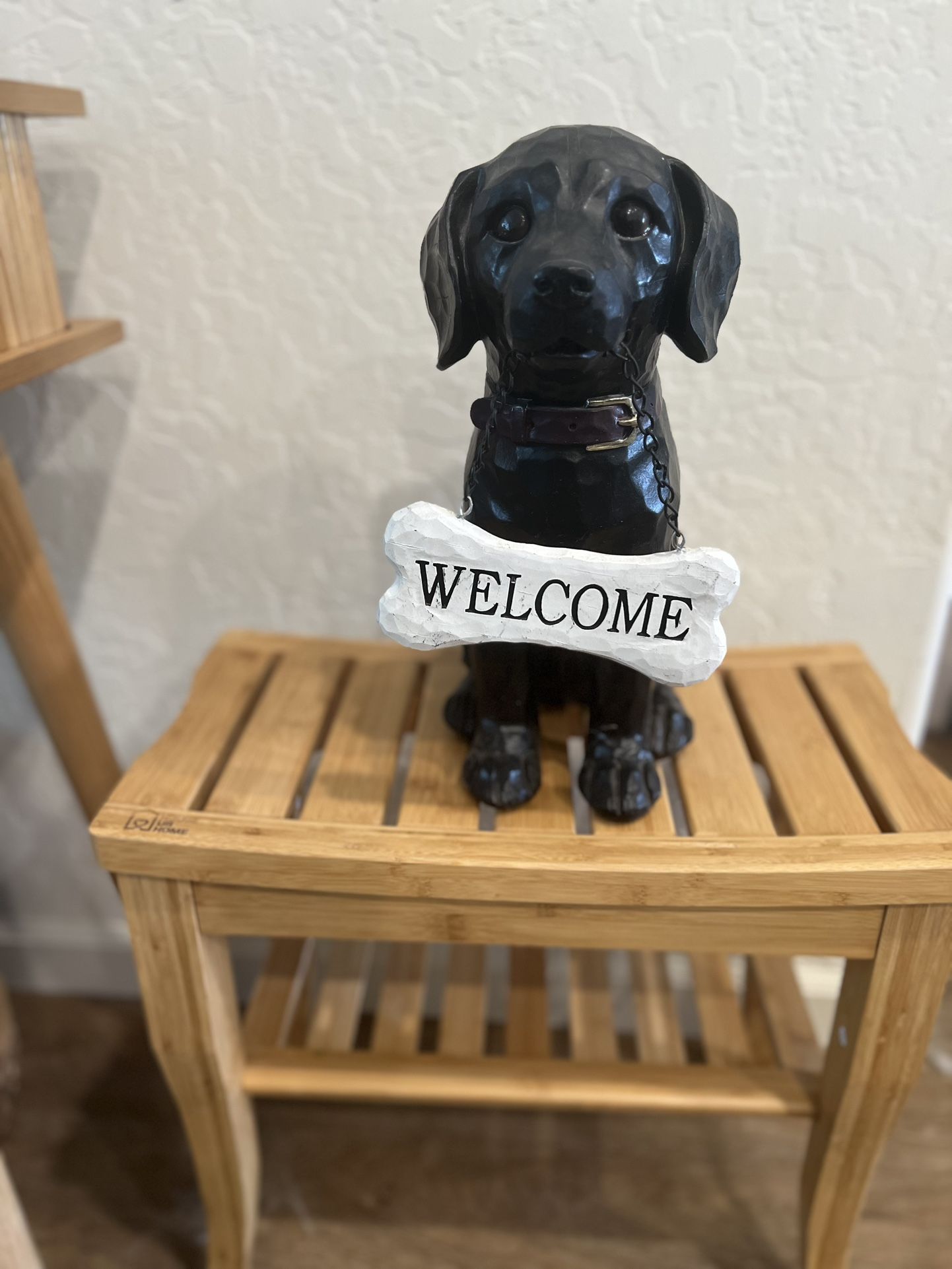 The statue features a bone-shaped sign with the word WELCOME from Hobby Lobby