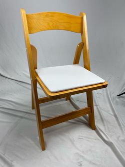 Natural Wood Folding Chair with Padded Vinyl Seat Natural wood folding chair with a comfortable padded seat covered in vinyl upholstery. Simple, clas