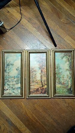 Vintage set of three vertical landscape paintings with gold-toned wooden frames.