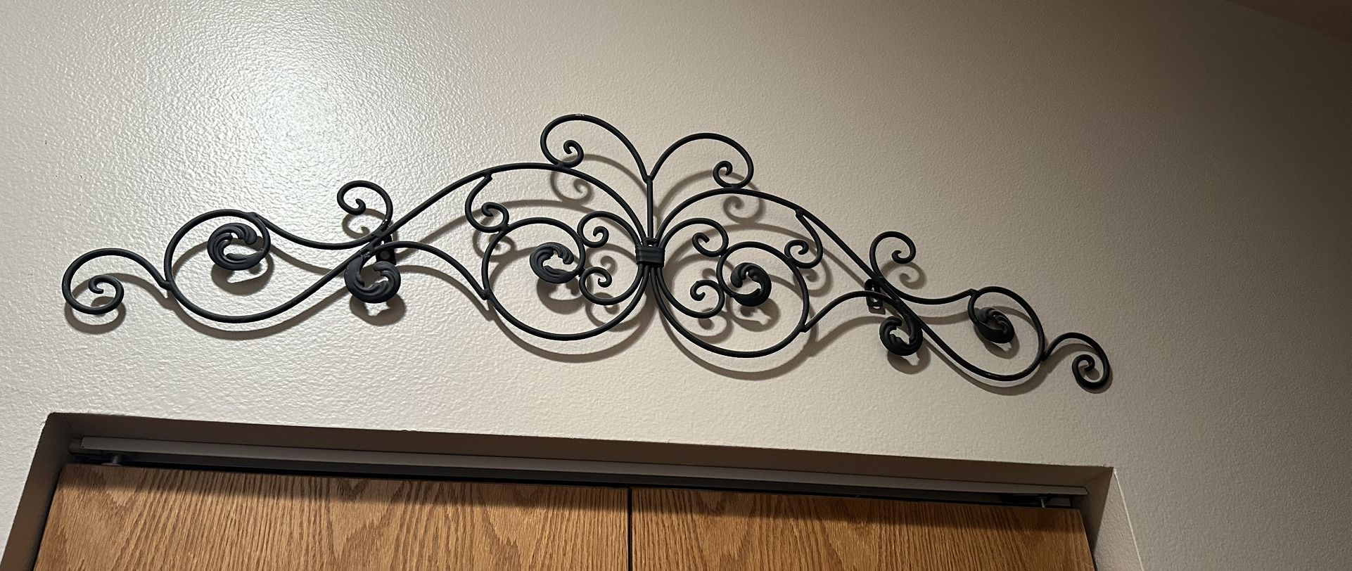 Wall hanging Metal Black Rod Iron from Hobby Lobby. Can be spray painted any color. Measures 12”Tx36”L