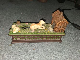 Dog cast iron painted pictures of 2 dogs sitting by there dog house.