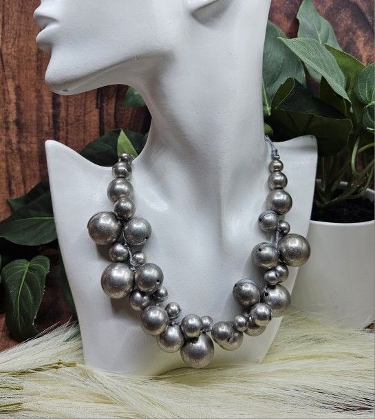 Silver Chunky Graduated Bead Necklace Statement Bold Haute Couture Assorted silver tone beads arranged in graduated manner.
Strung on ribbon with a lo