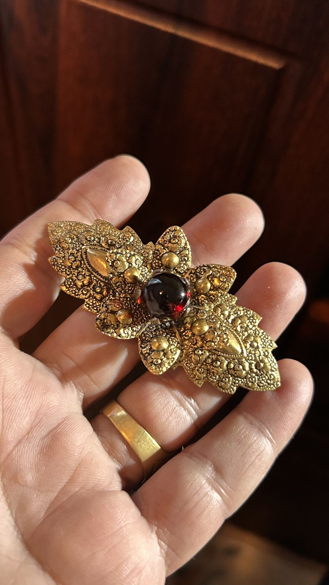 Vintage Gold Color Brooch With A Dark Red Gemstone
