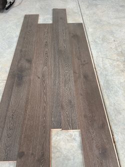 High-End engineered Laminate hardwood flooring in the color Amazing Greys by Max Windsor. This flooring has a dark grey-brown wood grain finish with a