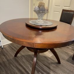 Brown wood dining room table set with included decorative vase