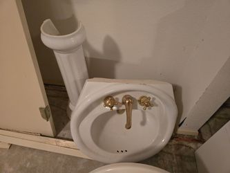 White porcelain pedestal sink w gold finishings