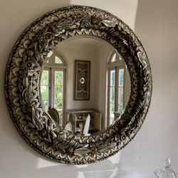 Large round ornate mirror featuring an antique silver &  gold/bronze finish - 48”