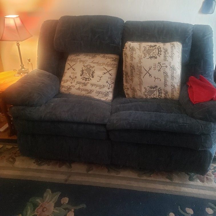 matching set of couch and loveseat. both have reclining seats and the couch has a fold down table for drinks .