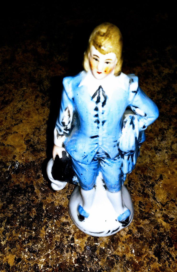 Charming porcelain figurine of a man dressed in 18th-century attire,
