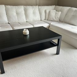 White sectional couch with black table