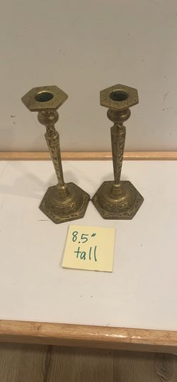 vintage brass repousse candlestick holder features ornate, embossed floral detailing along its hexagonal stem and base