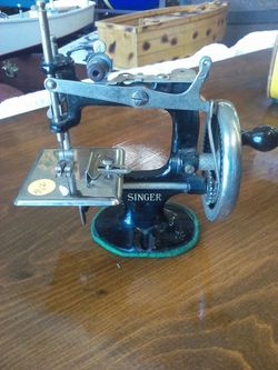 Mini Singer sewing machine 7 inches long and 7 inches tall all metal