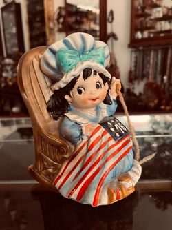 Vintage Ceramic Music Box – Colonial Girl in Rocking Chair with American Flag "76" Blanket, 16cm
