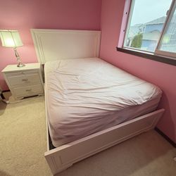 Queen Bed With A Mattress, A Nightstand And A Lamp.