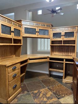 Large oak executive corner desk with matching hutch, glass-front cabinets, solid-wood drawer construction and heavy-duty hardware. Very substantial, w