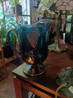 vintage Indiana Glass Co. pitcher in their iridescent blue "Carnival Glass" finish, featuring a distinct raised grape pattern.