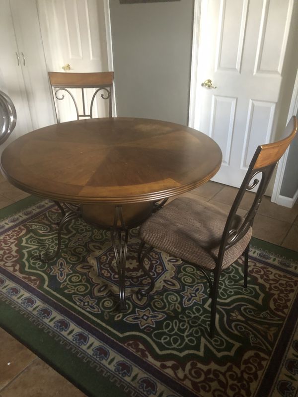Ashley wrought iron wood top round table and 4 chairs with padded seats