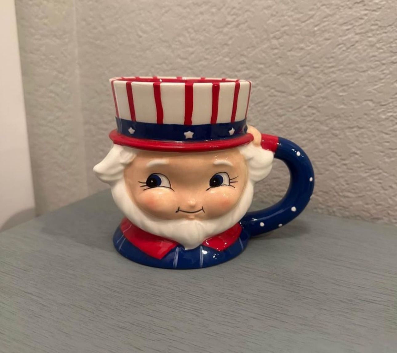 $12…New Adorable Uncle Sam mug in red, white & blue. Carnival Cottage by Joanna Parker and Magenta.  Measures 4.5” T x 6” W.   Please pickup in the ar