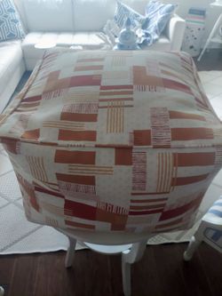 Pair if orange tone indoor, outdoor zippered poufs with handles
