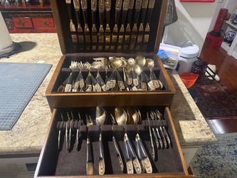 Vintage 90 piece PCL SIAM flatware set with a heavy solid wood chest. Beautiful gold tone utensils with dark handles and detailed decorative figures.
