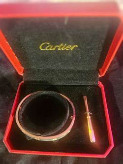 $100 Cartier Love Bracelet with its matching screwdriver, presented in a red brand box.
