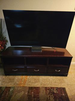 Tv stand.Dark brown/cherry; dimensions: 63" long, 19" wide, and 24" high.