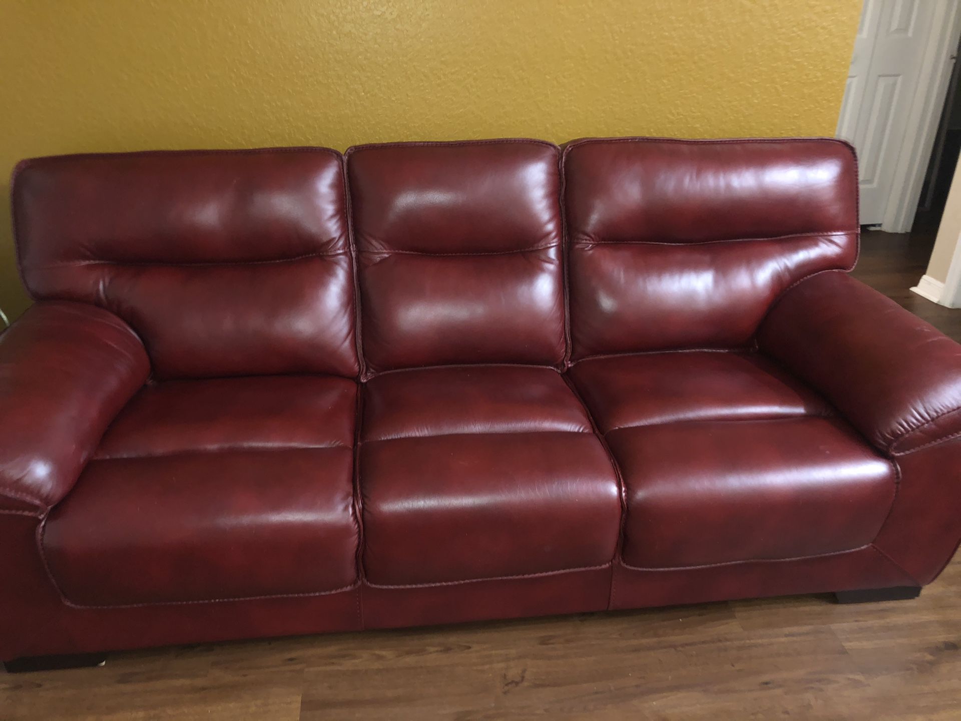 Like new Red Wine beautiful leather couch,love seat and 2 glass tables from Rooms to go $395