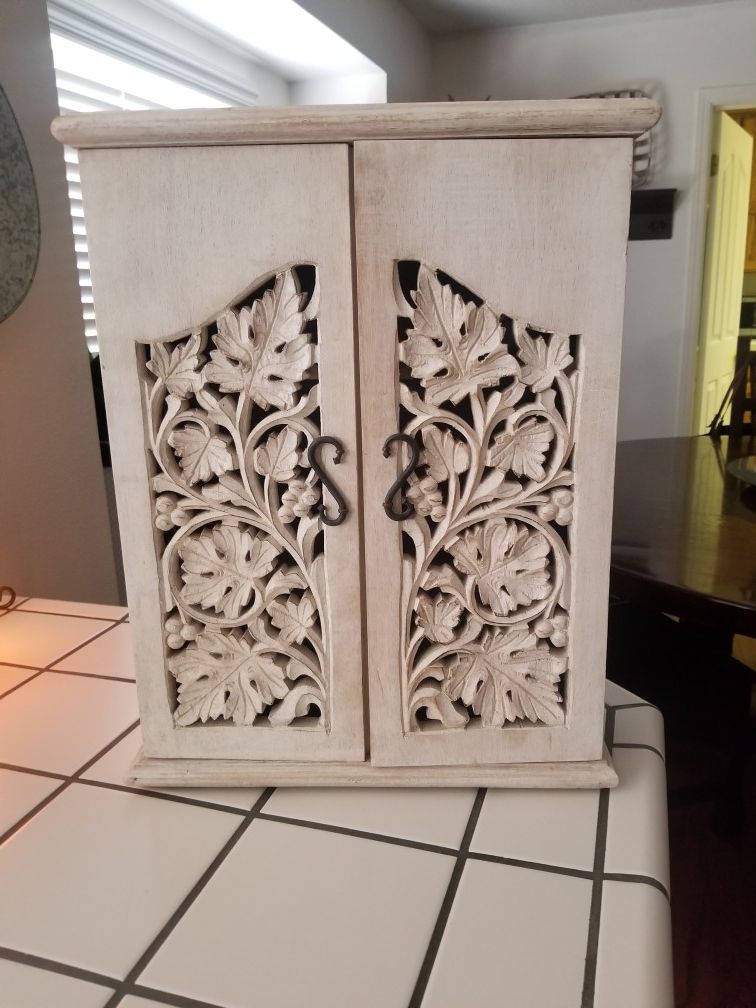 Cute white washed cabinet with carved leaves