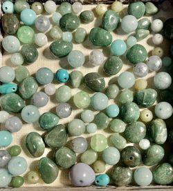 Assorted green and mint gemstone beads. Versatile mix for necklaces, bracelets, and DIY jewelry. Includes varying shades of green and mint for layered