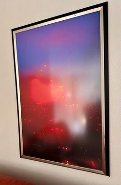 A pair of framed, monochromatic red abstract art print or photograph with a dark frame and silver inner matting.