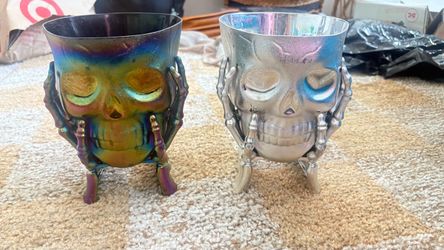 Set of two metal skull shaped plant pots or decoration