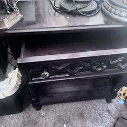 This is a dark wood end table or nightstand with gothic quatrefoil carved detailing. 