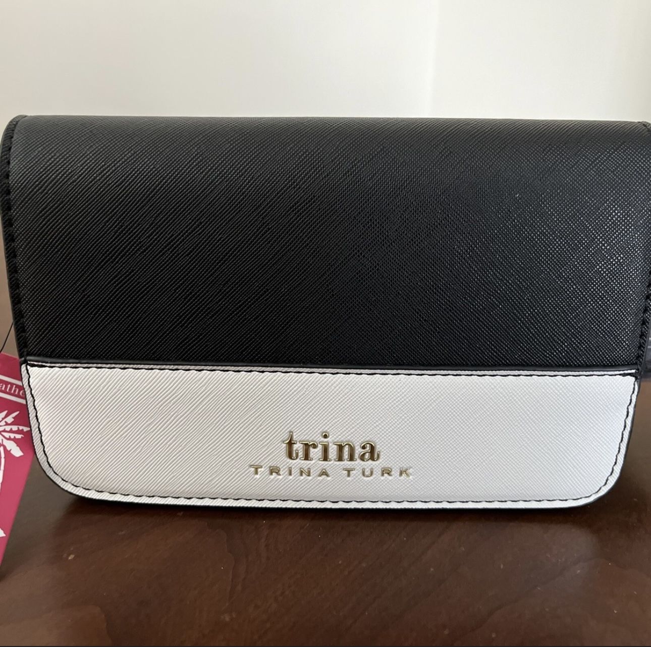 This is a Trina By Trina Turk Small Colorblock Vegan Leather Crossbody Bag in black and white