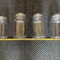 Preowned set of four large glass jars for sugars etc