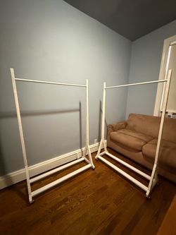 2 wood clothing racks on rollers