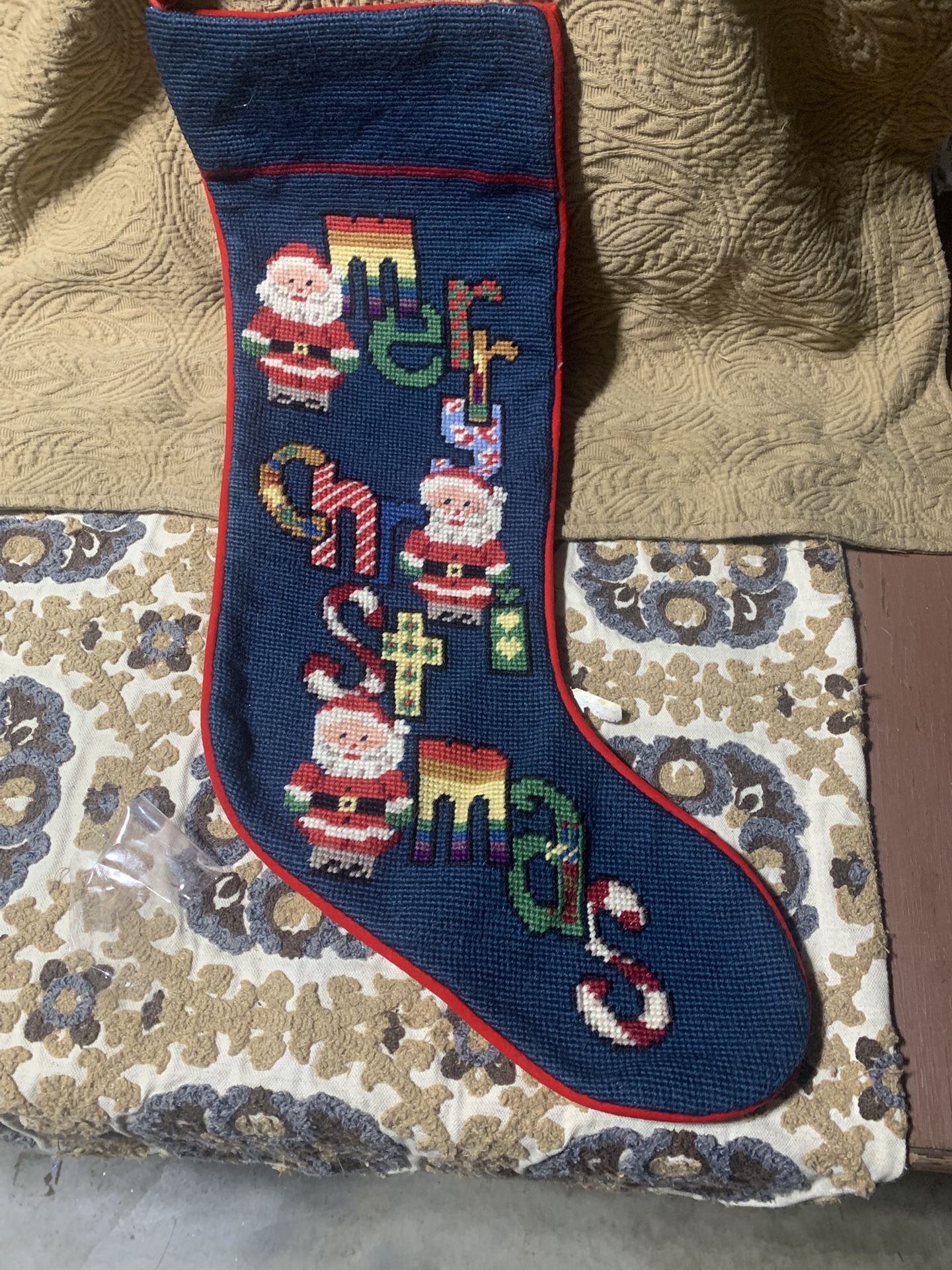 Handmade needlepoint Christmas stocking with Santa Claus and 'Merry Christmas' lettering