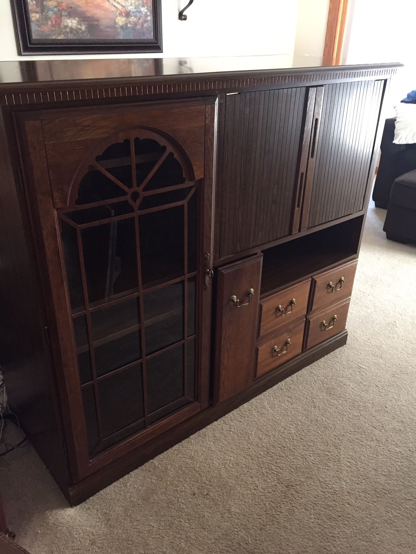 TV stand / storage wall unit, oak cabinet glass door front very good condition. The unit is 47" tall 55" wide and 21" deep.