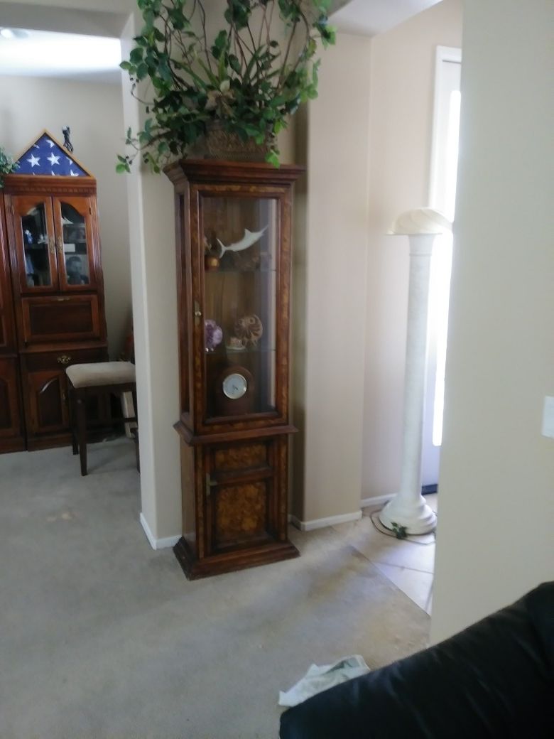 Tall wood cabinet with glass shelves & storage. Lights inside