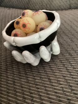Halloween Hand Holding Bowl of Rubber Eyes