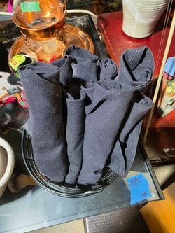 Durable black cloth napkins paired with a stainless steel fork and butter knife. Each set includes one folded fabric napkin and two pieces of silverwa