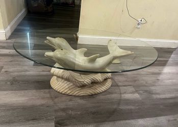 vintage coastal-themed dolphin coffee table featuring a sculpted plaster base and a clear glass top