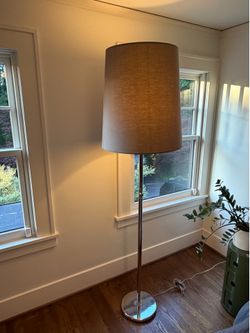 Modern Polished Chrome Floor Lamp with Oversized Drum Shade  Elegant contemporary floor lamp featuring a polished chrome stem and weighted circular ba