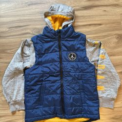 Kid’s Jordan Blue and Gray Hooded Vest with Yellow Accents Stylish blue quilted vest with gray hood and sleeves. Features yellow interior lining and a