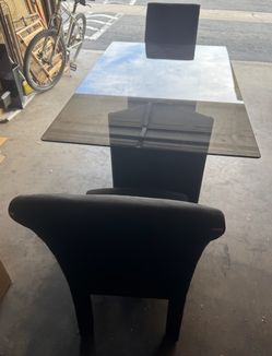 Tempered glass dining table. With two Chairs from the original set of four.